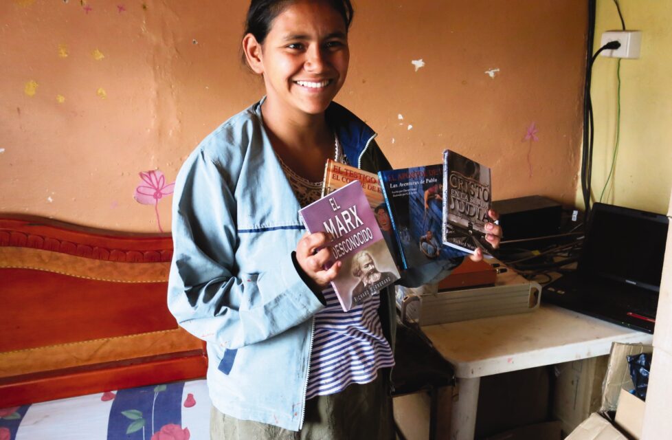 Former FARC Commander Now Front-Line Worker in Red Zones Colombian girl holds up literature