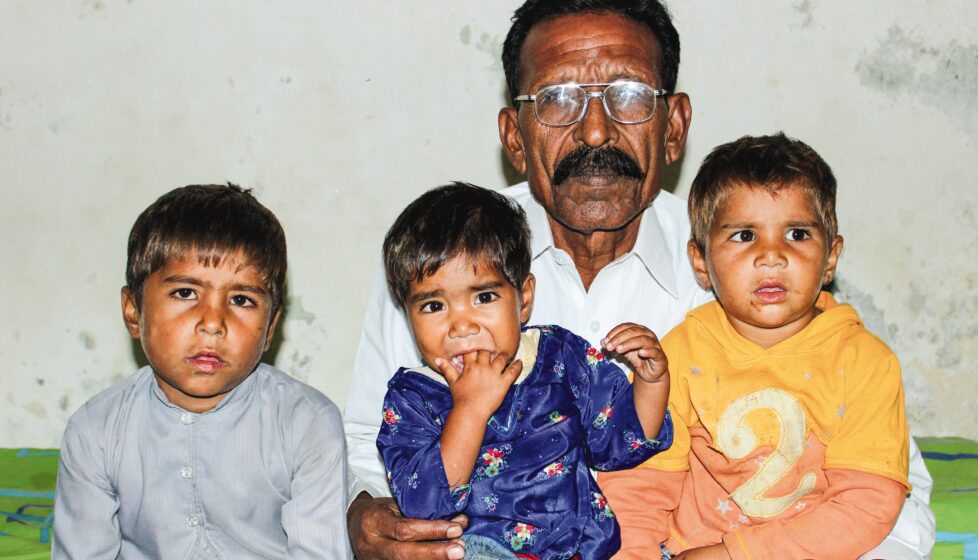 A man sits with his three kids
