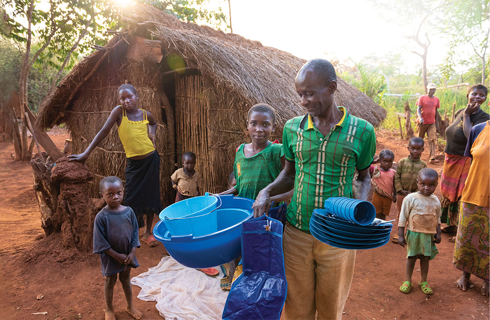 People outside house with buckets and dishes